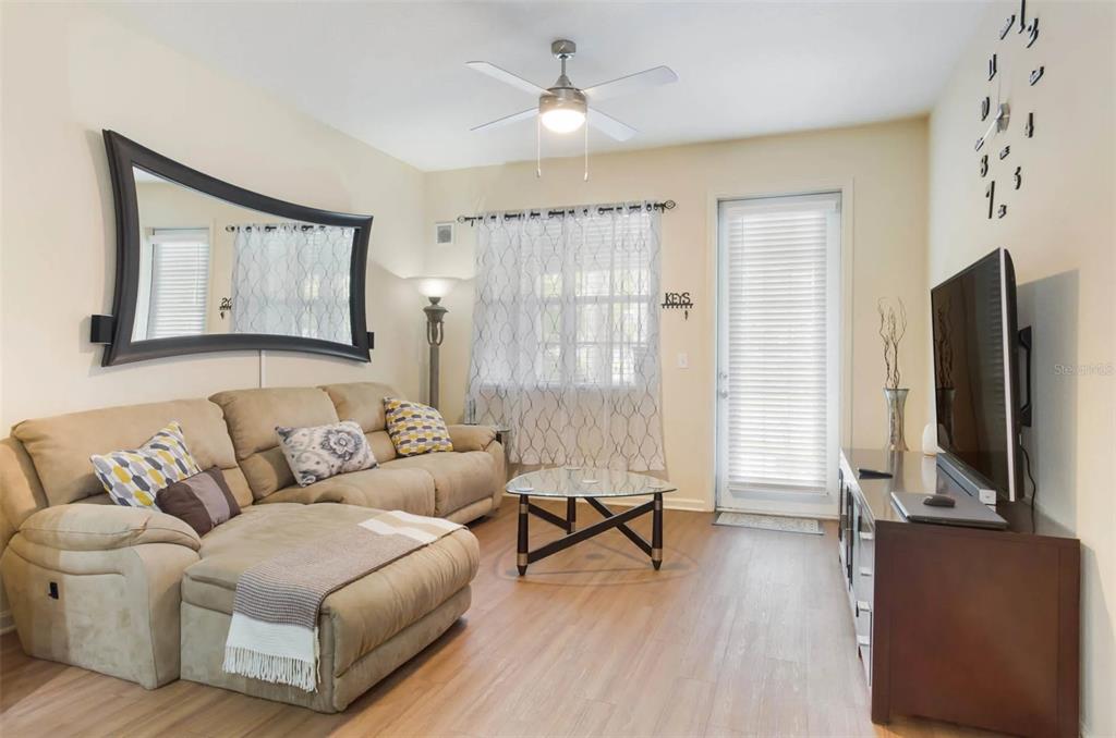 3334 South Bismark Lane, Unit 1B01304 Jupiter, FL 33458 - Photo 22 of 36 a living room with furniture and a flat screen tv