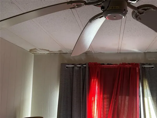 a bed sitting in a bedroom next to a window and tv