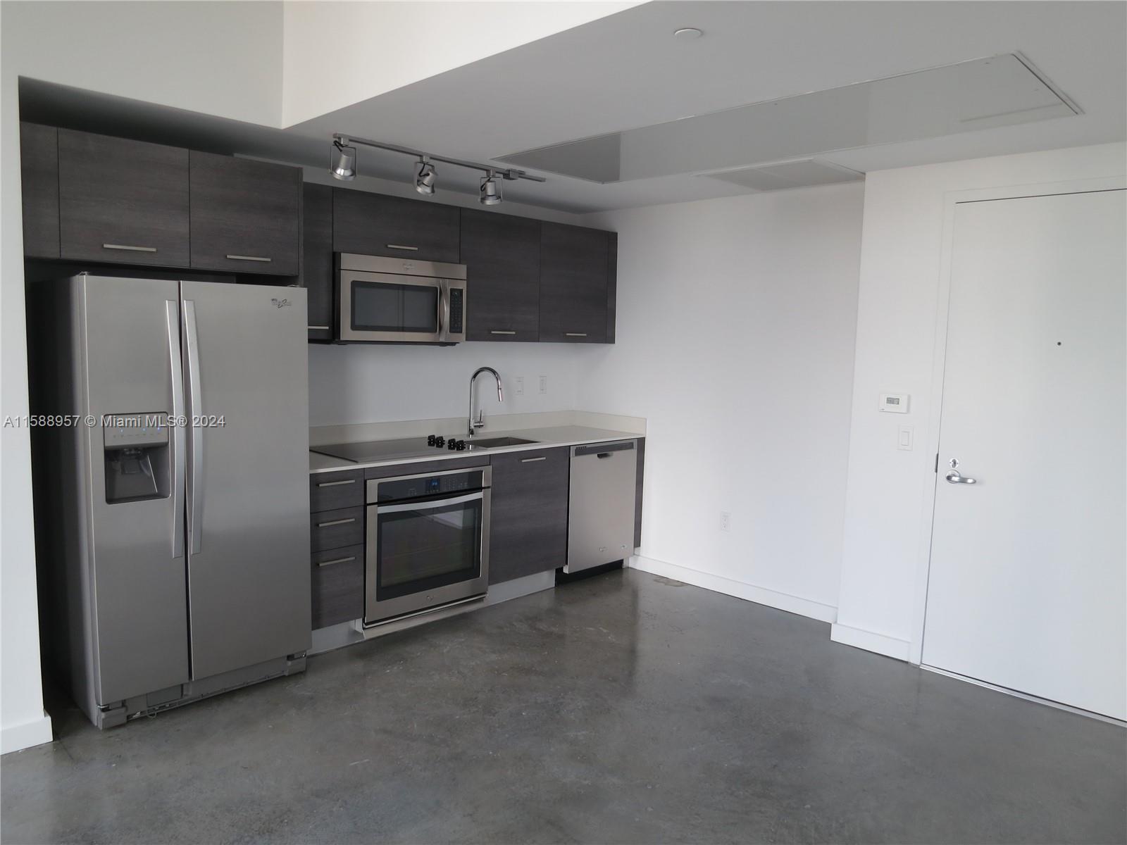 151 Southeast 1st Street, Unit 1704 Miami, FL 33131 - Photo 6 of 12 a kitchen with stainless steel appliances a refrigerator sink and microwave