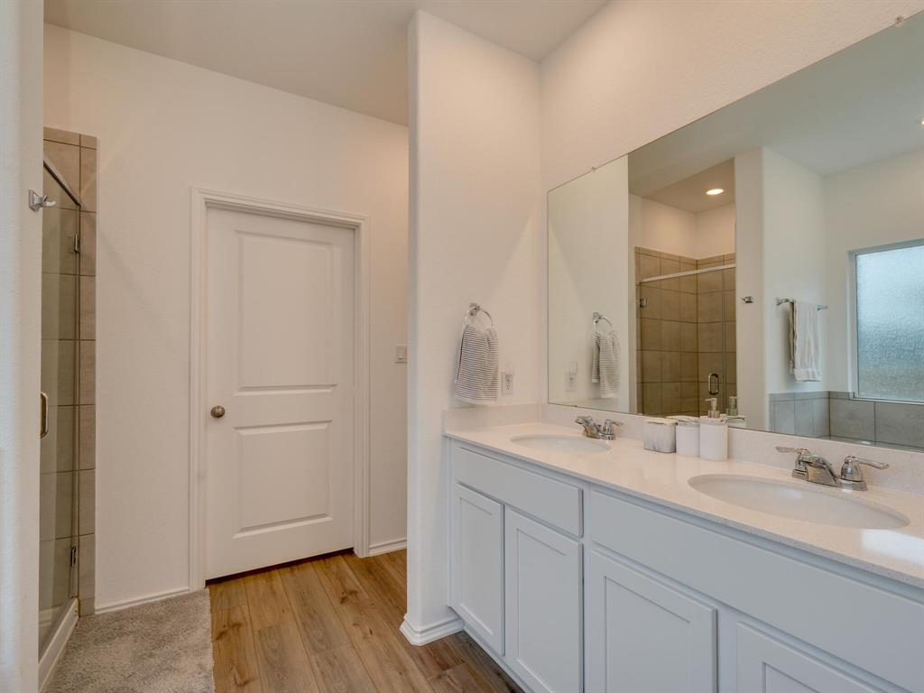1208 Sweetspire Street Leander, TX 78641 - Photo 15 of 36 Double vanity with undermount sinks, chrome fixtures, and white cabinetry