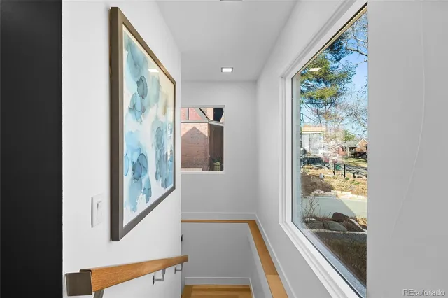 a view of hallway with wooden floor and a floor to ceiling window
