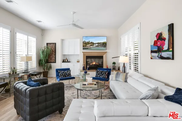 a living room with fireplace furniture and a large window