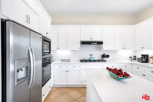 a kitchen with stainless steel appliances a sink a refrigerator and cabinets