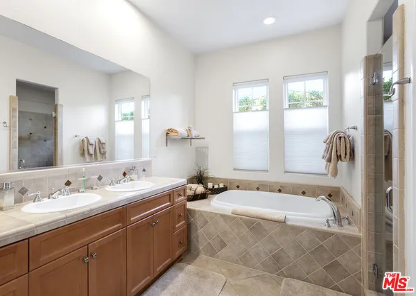 a spacious bathroom with a tub sink and mirror