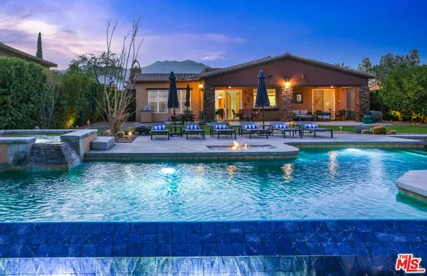 a backyard of a house with yard table and chairs