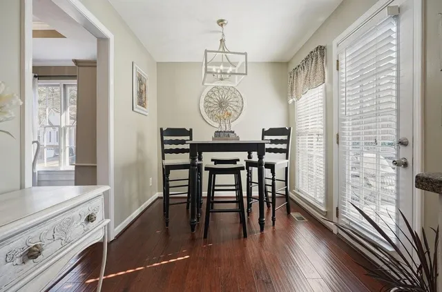 a kitchen with stainless steel appliances a white cabinets wooden floors and a sink