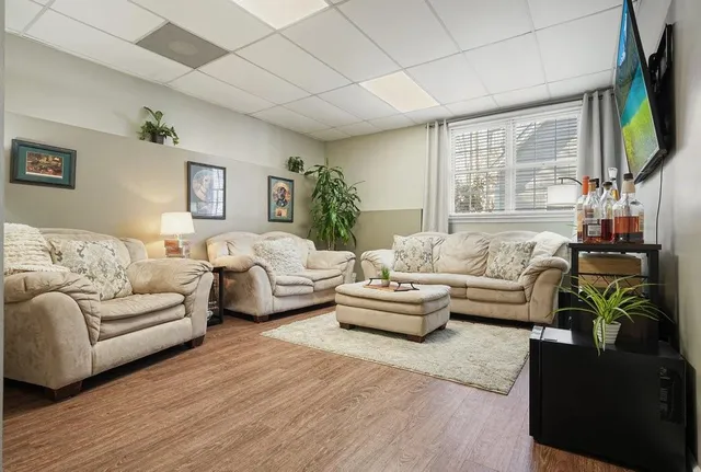 a view of a roof deck with table and chairs a barbeque with wooden floor and fence