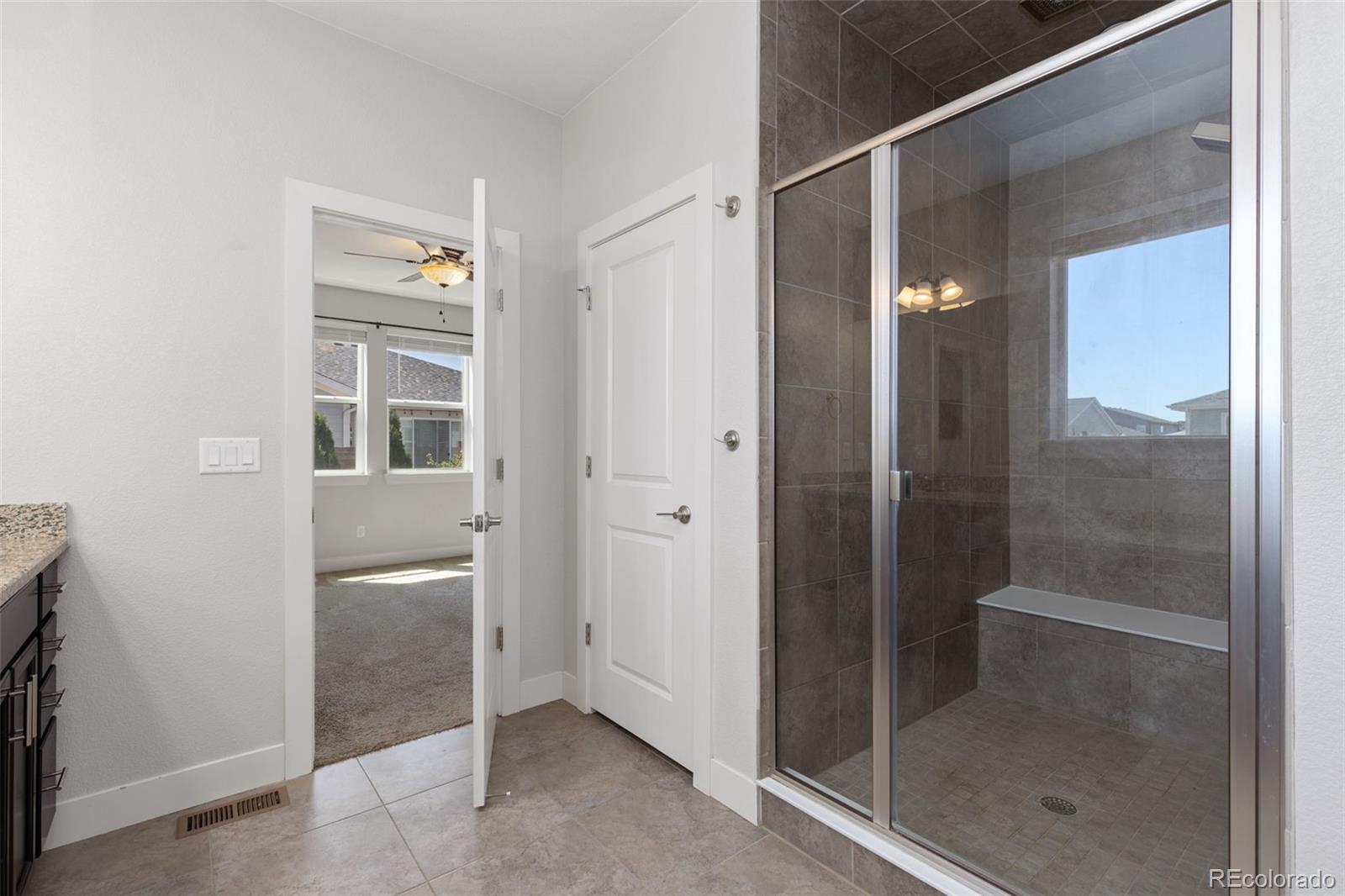 5540 Juniper Drive Brighton, CO 80601 - Photo 22 of 41 a bathroom with a glass shower door