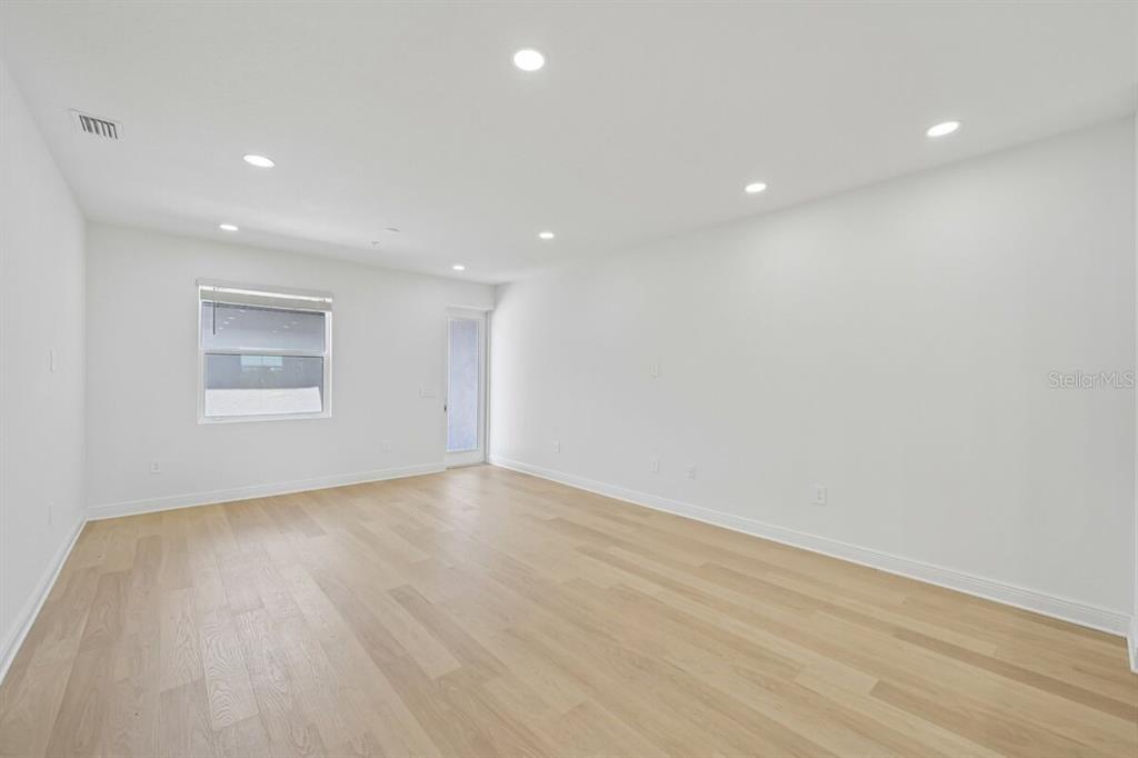 17712 Broadleaf Loop Venice, FL 34293 - Photo 6 of 23 an empty room with wooden floor and windows
