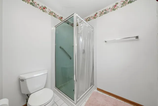 a bathroom with a toilet and a shower