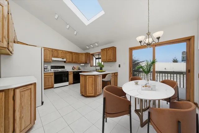a kitchen with a dining table chairs stainless steel appliances and cabinets