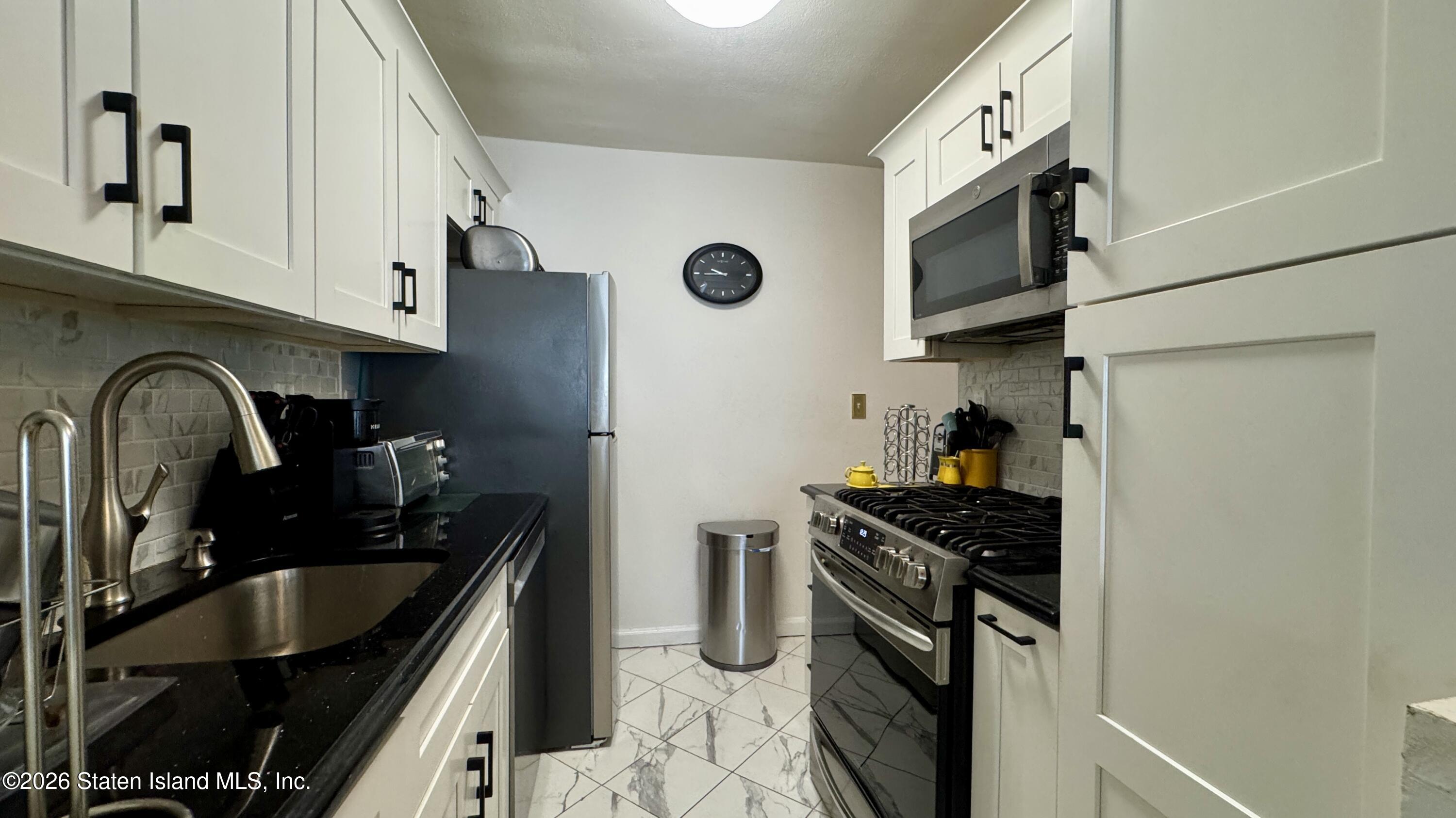 1100 Clove Road, Unit 2B Staten Island, NY 10301 - Photo 20 of 52 a kitchen with stainless steel appliances granite countertop a sink stove and refrigerator