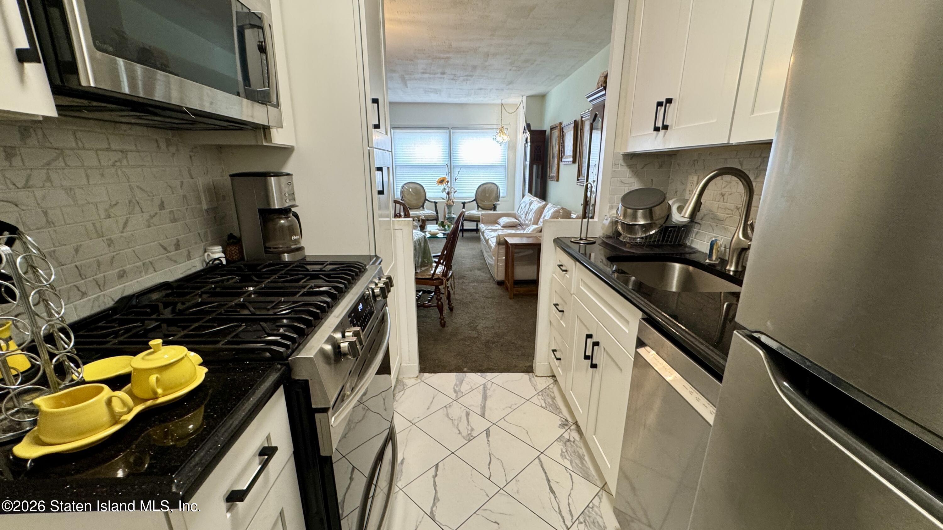 1100 Clove Road, Unit 2B Staten Island, NY 10301 - Photo 21 of 52 a kitchen with a sink appliances and cabinets