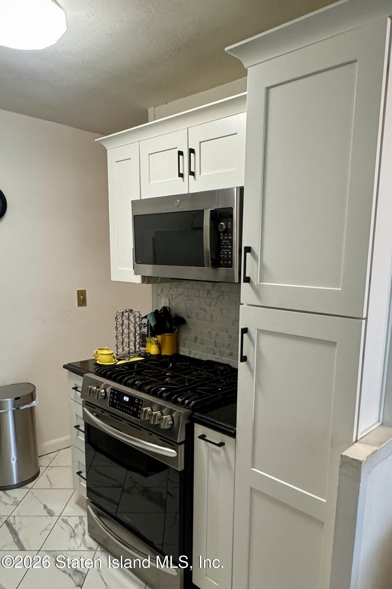 1100 Clove Road, Unit 2B Staten Island, NY 10301 - Photo 22 of 52 a kitchen with stainless steel appliances a stove a microwave and a sink