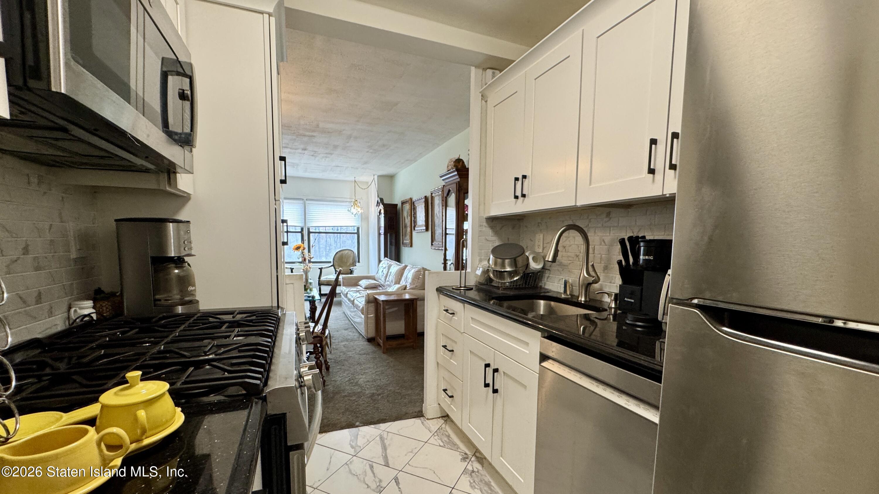 1100 Clove Road, Unit 2B Staten Island, NY 10301 - Photo 23 of 52 a kitchen with a sink and cabinets