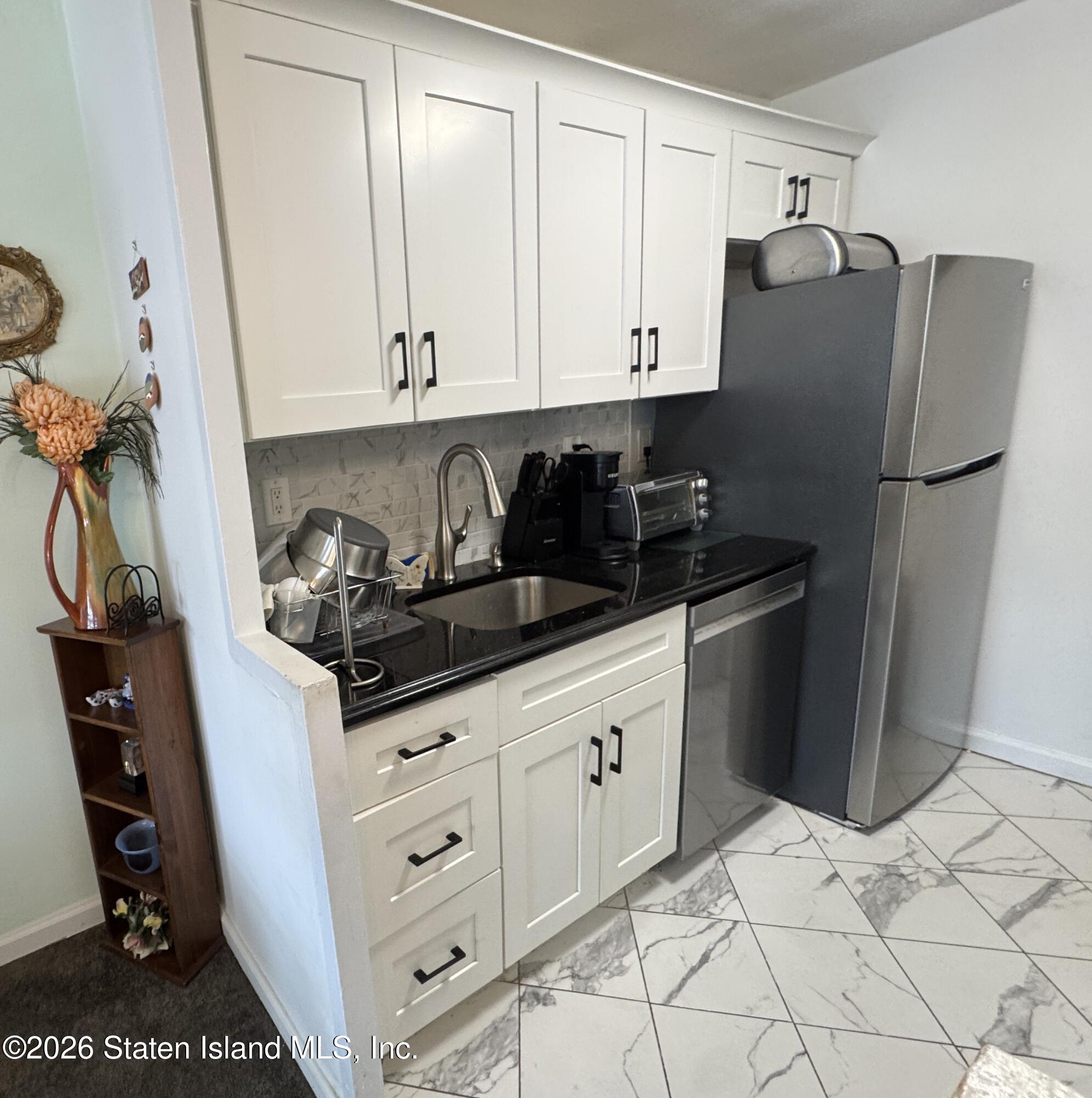 1100 Clove Road, Unit 2B Staten Island, NY 10301 - Photo 24 of 52 a kitchen with stainless steel appliances granite countertop a refrigerator and a stove