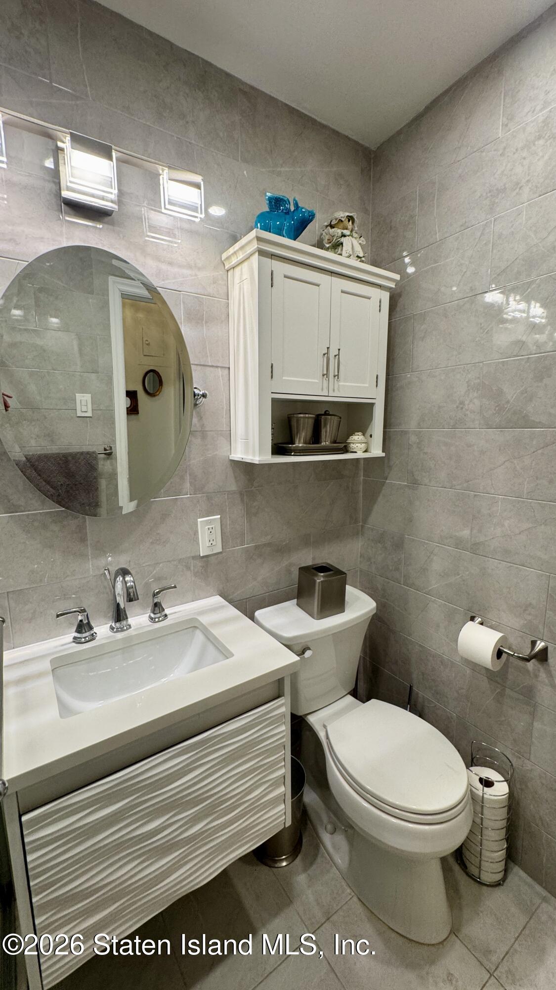 1100 Clove Road, Unit 2B Staten Island, NY 10301 - Photo 28 of 52 a bathroom with a toilet a sink and mirror