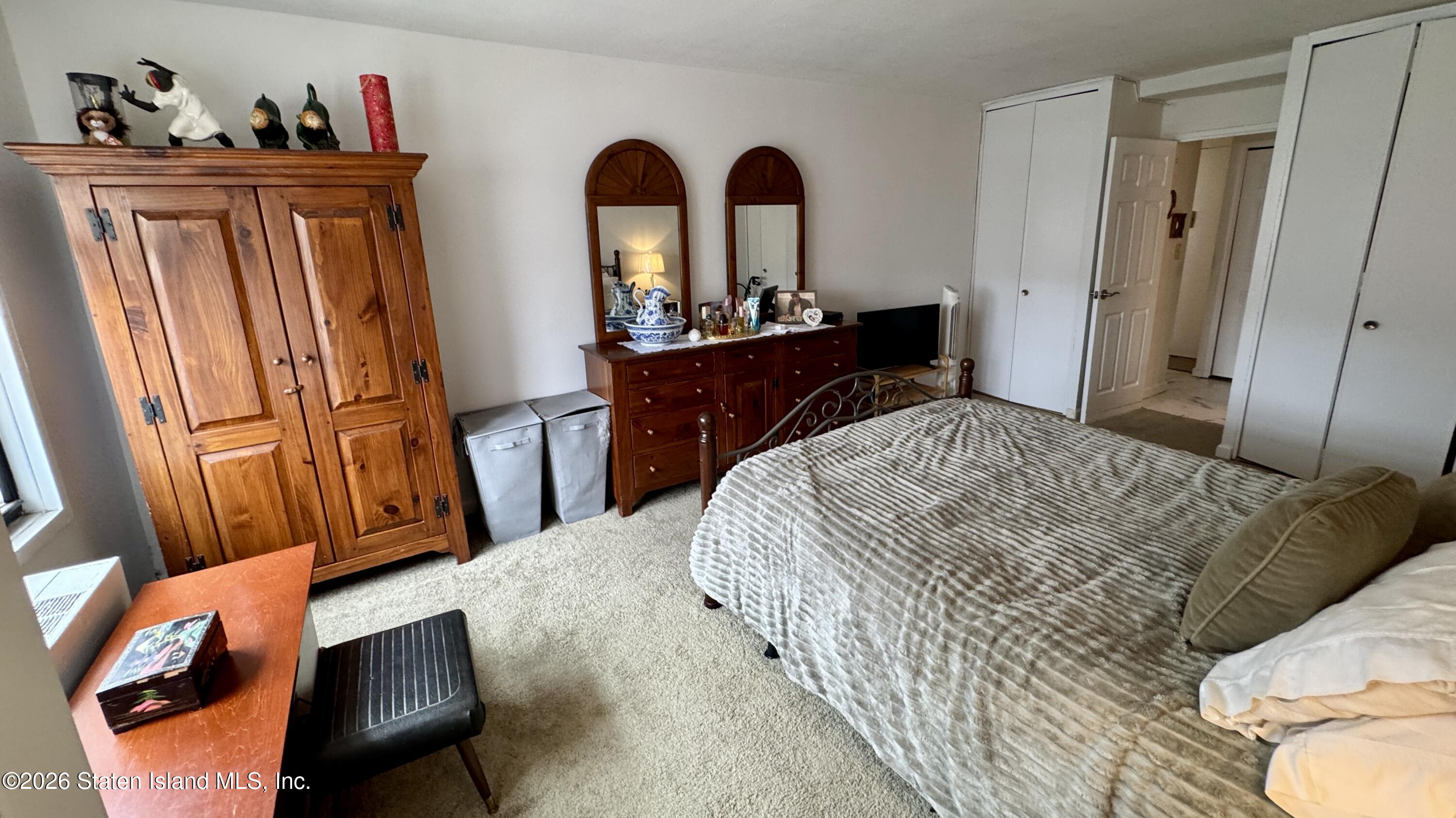 1100 Clove Road, Unit 2B Staten Island, NY 10301 - Photo 35 of 52 a bedroom with a large bed and a dresser