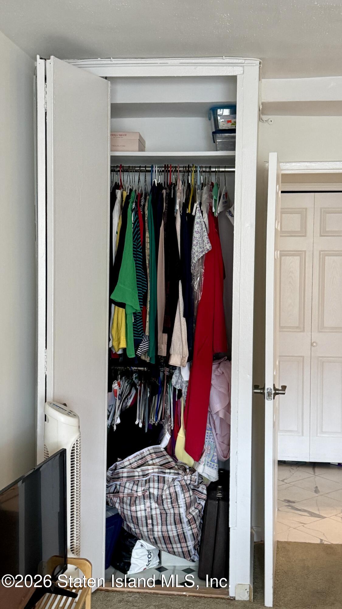 1100 Clove Road, Unit 2B Staten Island, NY 10301 - Photo 39 of 52 a view of walk in closet with clothes and shoes