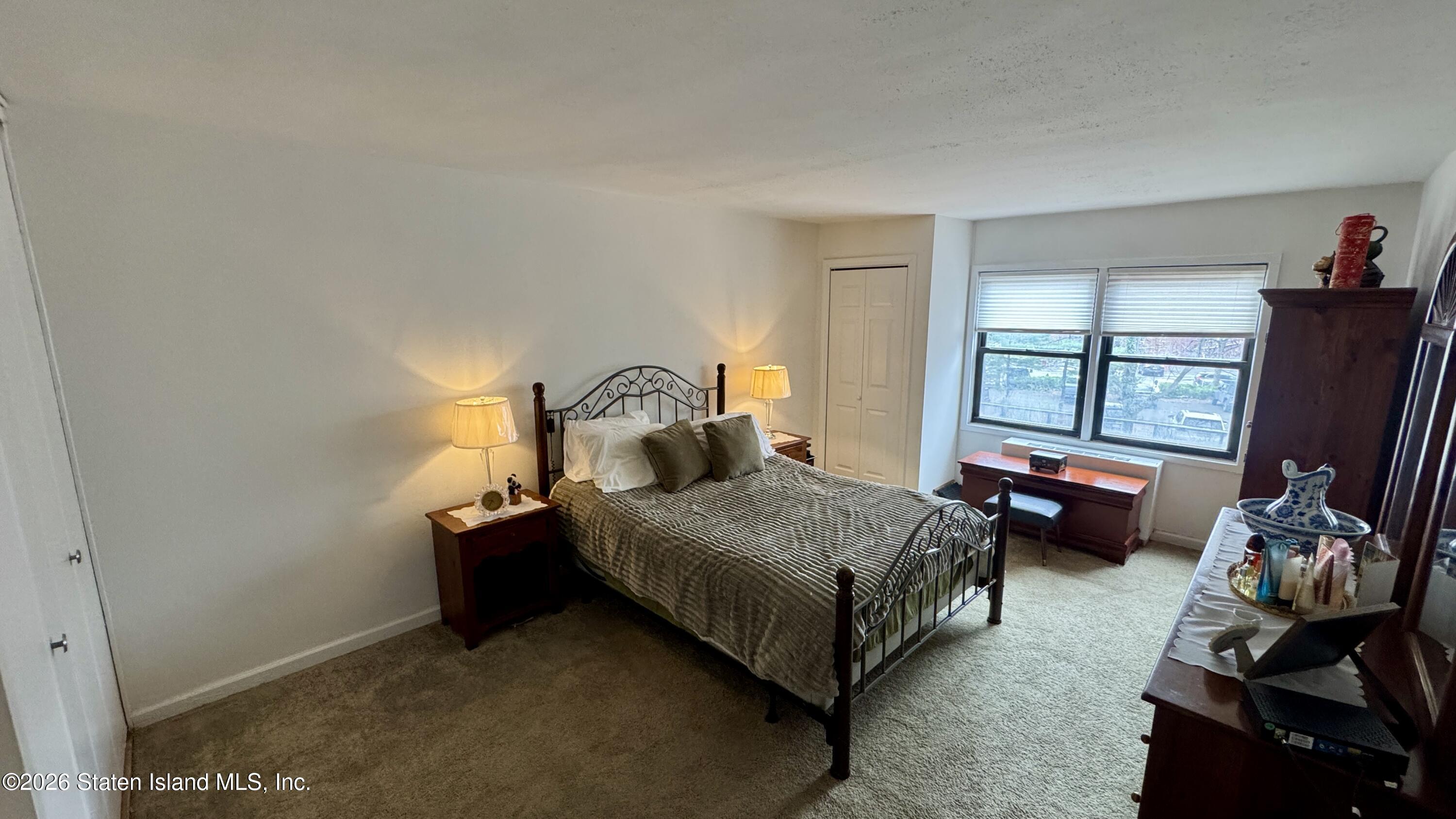 1100 Clove Road, Unit 2B Staten Island, NY 10301 - Photo 45 of 52 a bedroom with a bed and a flat tv screen next to a window