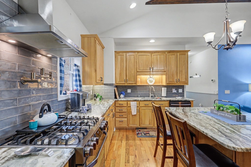 340 Country Mountain Ridge Drive Murphy, NC 28906 - Photo 35 of 73 a kitchen with stainless steel appliances granite countertop a stove a sink dishwasher a dining table and chairs with wooden floor