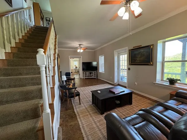 a living room with furniture two window and wooden floor