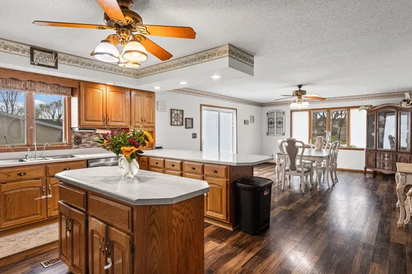 a kitchen with a table chairs stove and wooden floor