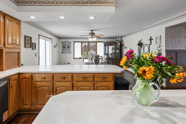 a kitchen with stainless steel appliances a sink a stove a refrigerator cabinets and a large window