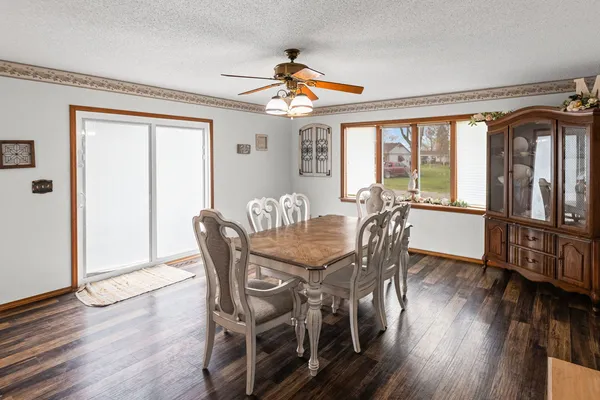 a kitchen with stainless steel appliances granite countertop a table chairs and a wooden floors