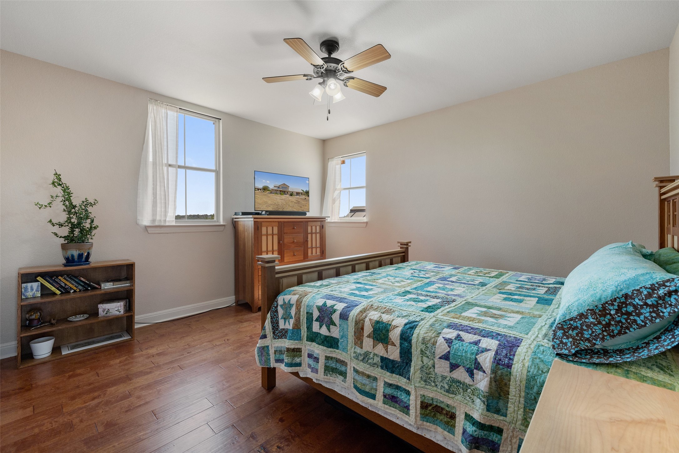 1120 Canyon View Road Dripping Springs, TX 78620 - Photo 20 of 40 a bedroom with a bed and a chandelier