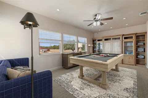 a living room with furniture and a large window with kitchen view