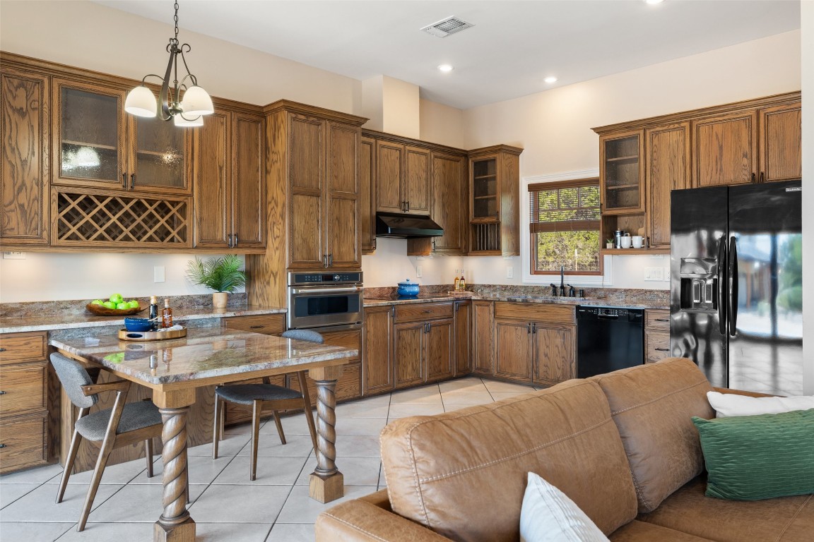 1120 Canyon View Road Dripping Springs, TX 78620 - Photo 27 of 40 a kitchen with a stove a sink a dining table and chairs