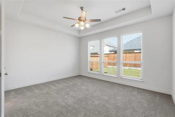 an empty room with ceiling fan and window