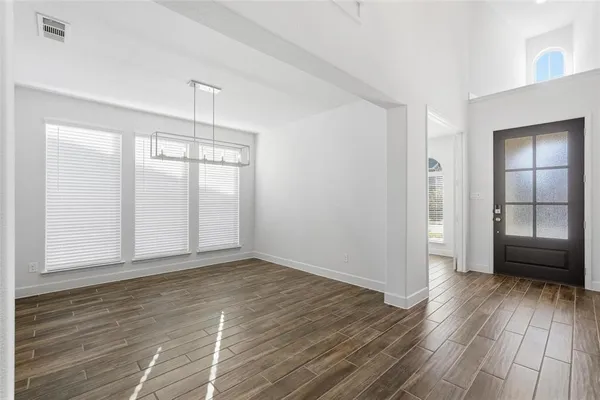 an empty room with wooden floor and a window