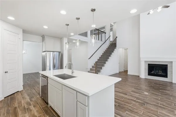 a kitchen with stainless steel appliances kitchen island granite countertop a refrigerator a sink and a stove