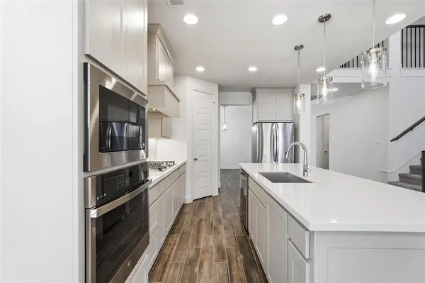 a kitchen with kitchen island a sink stove and refrigerator
