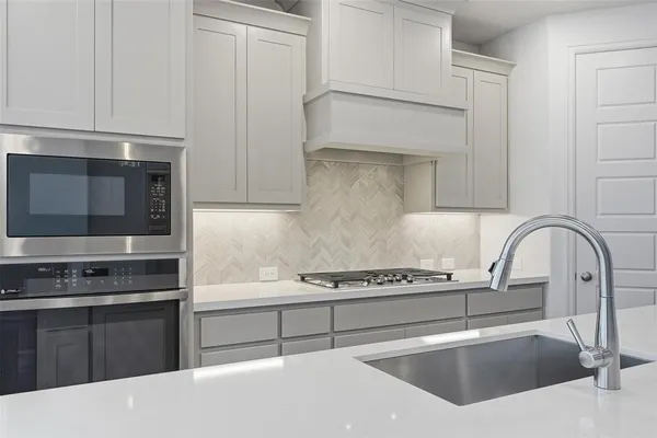 a kitchen with stainless steel appliances kitchen island a stove and a microwave