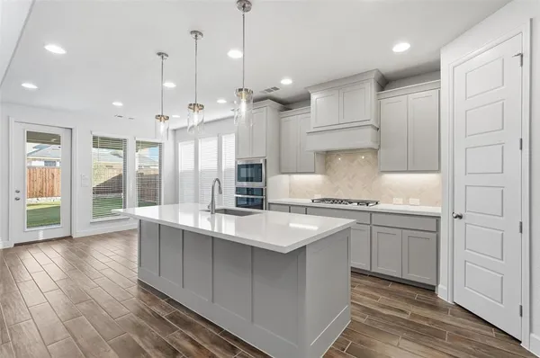 a large kitchen with kitchen island a sink stainless steel appliances and cabinets