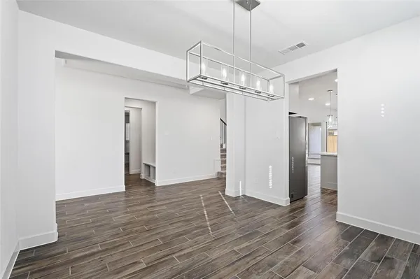 a view of a room with wooden floor staircase and a chandelier