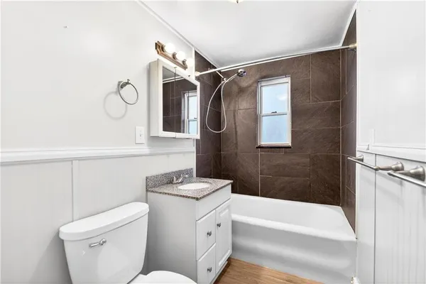 a bathroom with a granite countertop sink toilet a mirror and shower