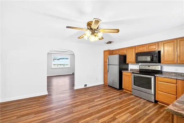 a kitchen with stainless steel appliances granite countertop a refrigerator and a stove top oven