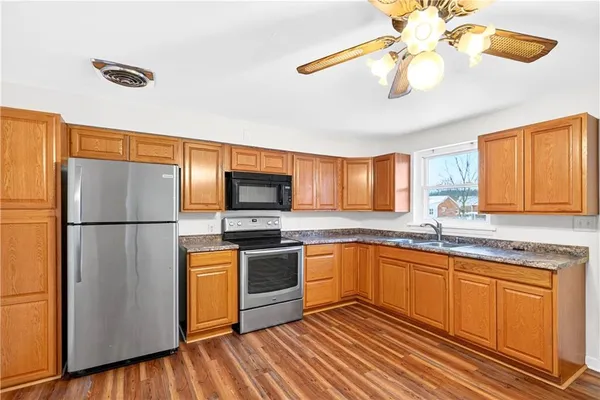 a kitchen with stainless steel appliances a stove a sink and a refrigerator