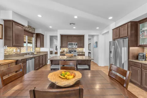 a view of a dining room with furniture and a kitchen