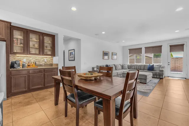 a living room with couches and large window with kitchen view