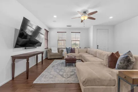 a living room with furniture and a wooden floor