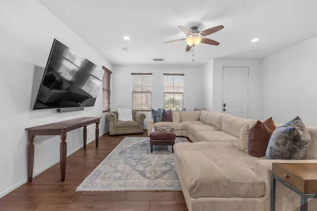 a living room with furniture and a wooden floor