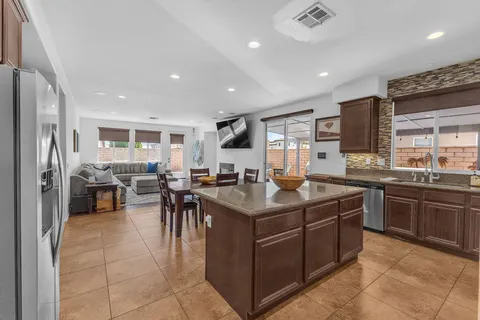 a kitchen with stainless steel appliances kitchen island granite countertop a table and chairs