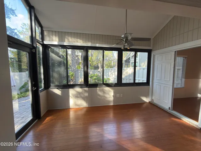 a view of empty room with wooden floor and fan