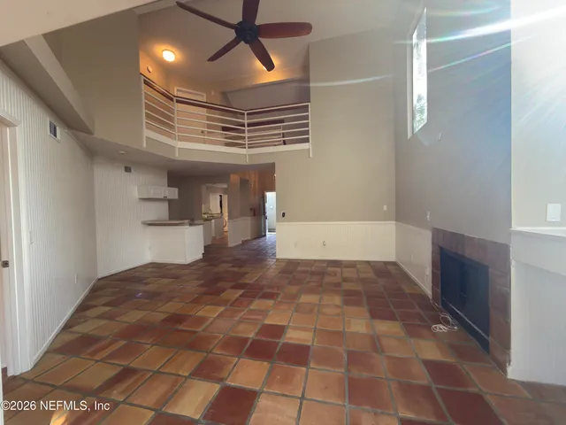 a view of empty room with wooden floor and window