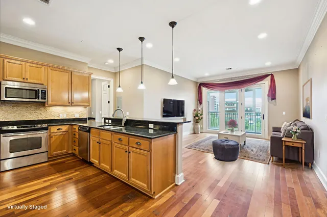 a kitchen with stainless steel appliances granite countertop wooden cabinets a stove a sink and a wooden floors